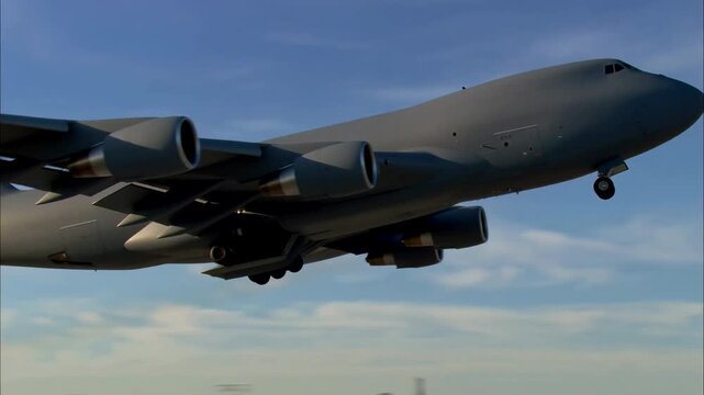 Large four-engine transport aircraft lifts from runway and climbs through blue sky with landing gear partly extended, viewed from low side angle above airport grounds