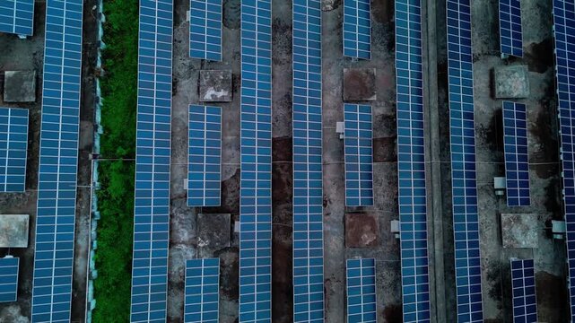 Aerial view of rows of blue solar panels installed on a rooftop in Surat, Gujarat, India.