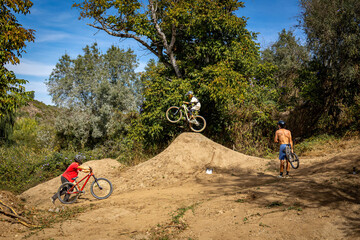 Obraz premium Dirt bike rider jumping on a dirt track in Arripiado village by the Tagus River, Portugal