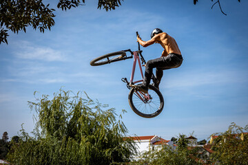 Obraz premium Dirt bike rider jumping on a dirt track in Arripiado village by the Tagus River, Portugal