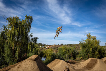 Obraz premium Dirt bike rider jumping on a dirt track in Arripiado village by the Tagus River, Portugal