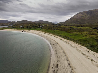 Aerial view of serene coastal inlet, calm waters, rocky shorelines, and distant hills. Overcast sky casts soft light over tranquil scene. Ideal for travel, nature, or environmental themes © mark_gusev