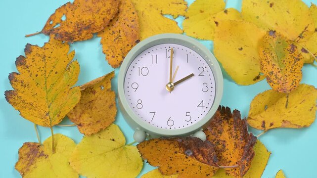 End of daylight saving time in autumn, winter time changeover, alarm clock fall back switch, colorful foliage