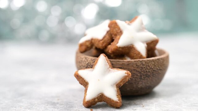 Christmas holiday sweets, homemade cinnamon stars with hazelnuts and almonds, cookies and biscuits with icing glaze, bokeh light