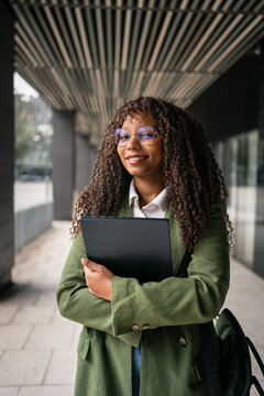 African American Businesswoman Holding Folder in Modern Office Corridor