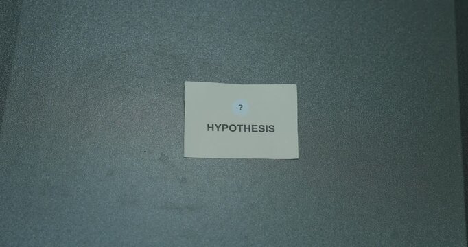 Hypothesis text on a white paper card against a gray background, representing scientific research, testing and evidence based reasoning