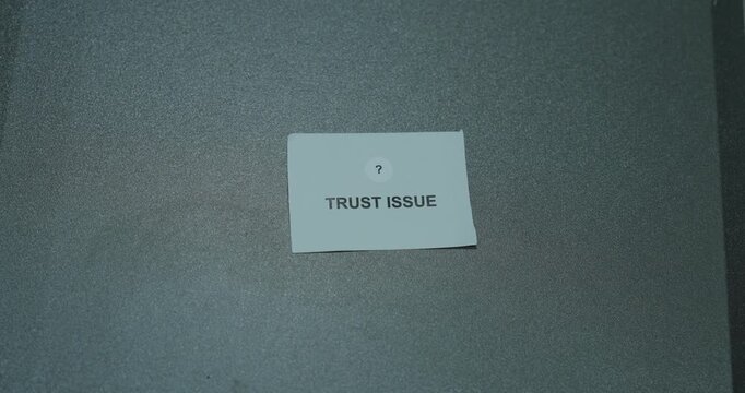 Trust issue text on a white paper card against a gray background, representing doubt, insecurity and relationship challenges
