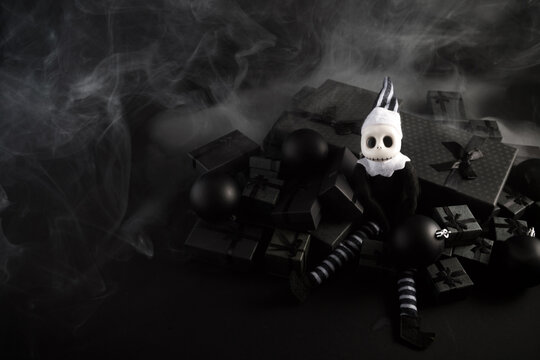 Skeleton doll sitting on dark christmas gifts with smoke