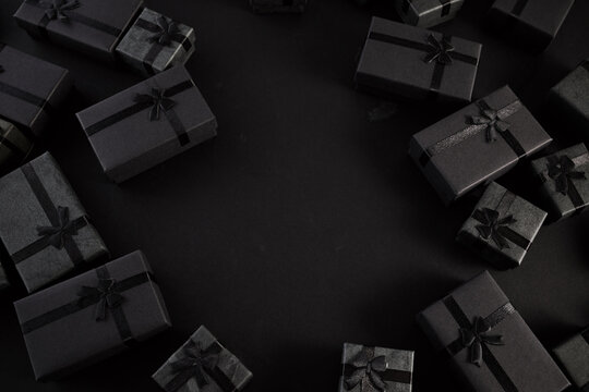 Black gift boxes creating frame on dark background