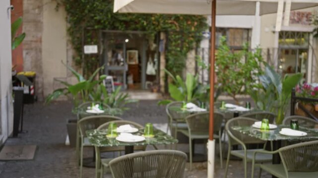 Outdoor cafe terrace softly blurred bokeh with shallow focus on tables and plants, street frame; background backplate copyspace calm.
