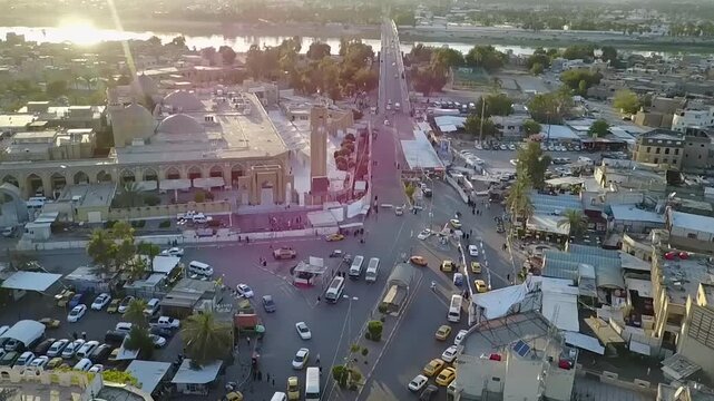 Aerial view of Abu Hanifa Mosque, clock tower and busy square in Adhamiyah at sunset, Baghdad