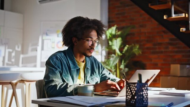 Startup employee typing laptop home office. Smiling african american freelancer.