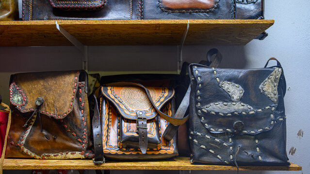 Handmade leather purses on a retail display at a saddlery shop.