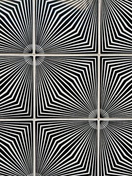 Black and white azulejo tiles with starburst line pattern on a wall in Portugal