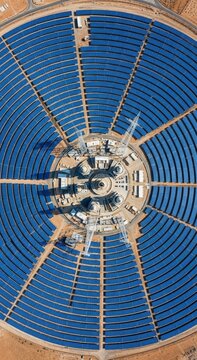 Sustainable Energy Hub aerial top-down view of circular solar panel arrays in a desert landscape ideal for renewable energy articles and environmental sustainability campaigns. Vertical. Portrait.