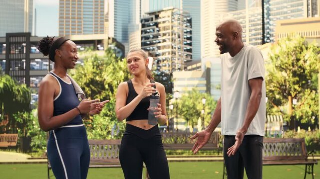 Yoga friends exchange a cheerful group fist bump after exercising in city park, expressing teamwork, encouragement, shared fitness motivation and joyful support among proud participants.