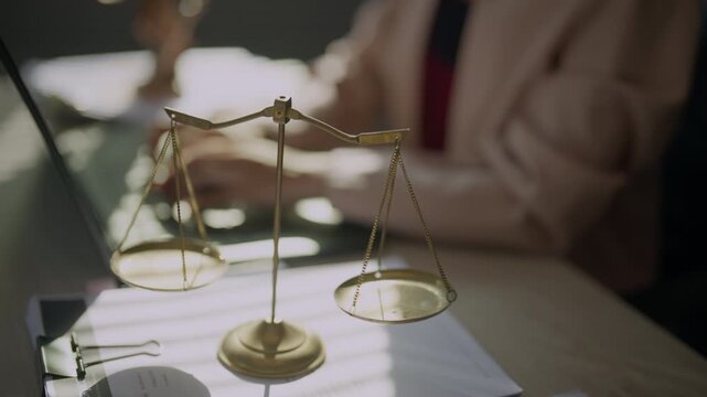 Attorney preparing a legal case on a computer beside scales of justice, representing evidence review, litigation research, case management, judicial procedures, digital records, and legal expertise.