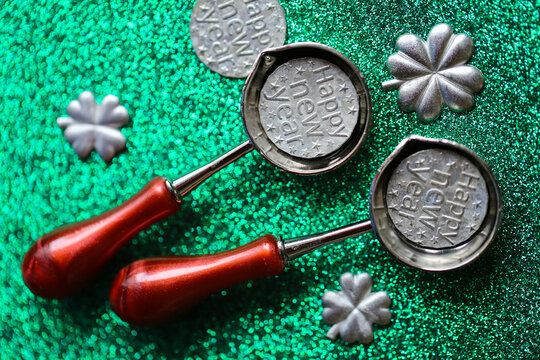  Silver Shamrock Molds on Green Glitter Background. Tin Pouring Set on Green Glitter Background for tin pouring instructions,holiday gift sets and New Year fortune telling activities