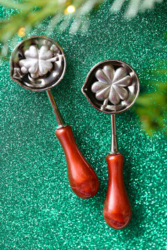 Happy New Year Lucky in Tin Pouring Spoons on green glitter. traditional holiday prediction game for family celebrations,holiday greetings,fortune telling traditions,party invitations 