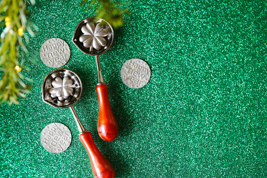 New Year Tin Pouring Set with Green Glitter Copy Space for New Year banners, invitations, cultural articles and holiday promotions.