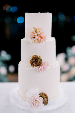 Elegant three tier wedding cake with pastel flowers