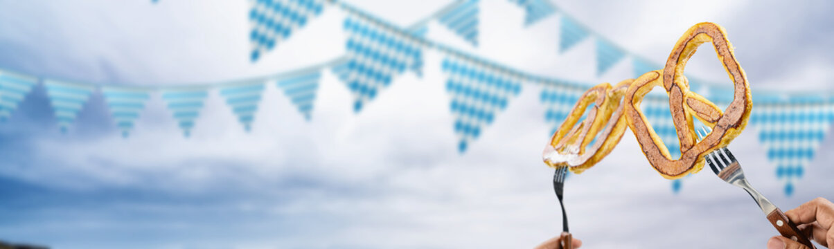 Bavarian pretzels held up on forks against festive blue and white pennant banner background, capturing the spirit of Oktoberfest and traditional German food celebrations. Bavarian Oktoberfest Festival