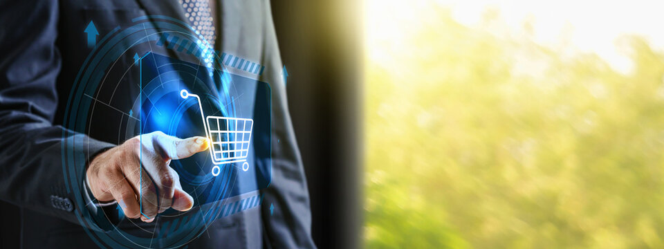 Businessman touching a virtual shopping cart icon on a futuristic digital display, symbol e-commerce, online shopping, and digital marketing. Concept of Online shopping, E-commerce and Modern Retail