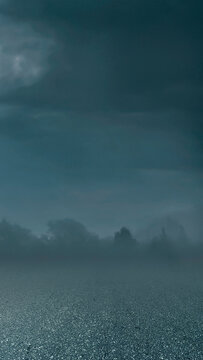 An asphalt road stretching into a moody, foggy landscape with dark stormy clouds above, creating a mysterious and atmospheric setting. Smoke background