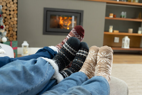 African American family reclining on couch at home wearing patterned wool socks near fireplace