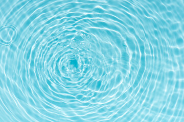 Fototapeta premium Blue water with ripples on the surface. Defocus blurred transparent blue colored clear calm water surface texture with splashes and bubbles. Water waves with shining pattern texture background.