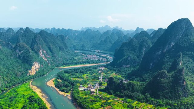 Aerial view reveals lush karst mountains and a meandering river valley near Xianggong Mountain in Guilin during bright daylight.