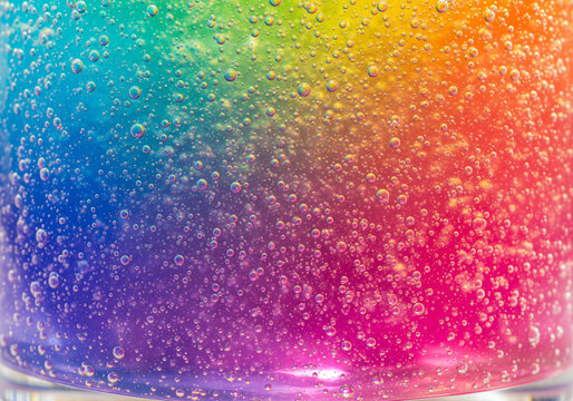 Vibrant rainbow colored gel texture filled with sparkling air bubbles