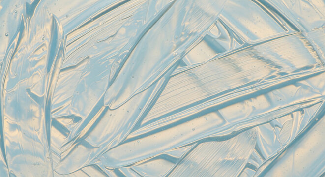 Abstract brush strokes texture of clear cosmetic gel with warm lighting