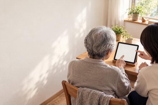 Wide view of older adult learning a new device with support