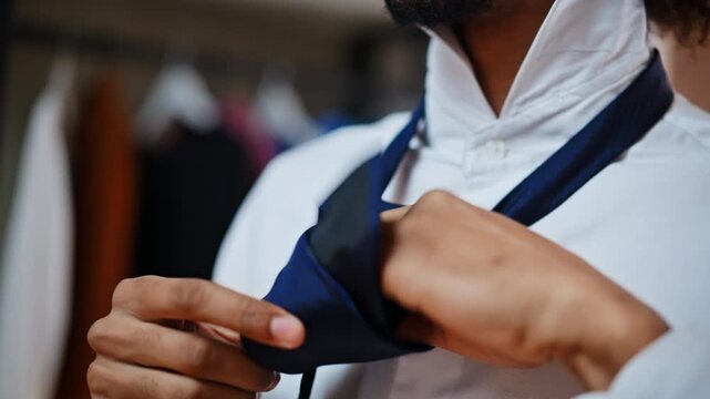 Businessman knotting blue necktie white shirt. Close up hands dressing wardrobe.