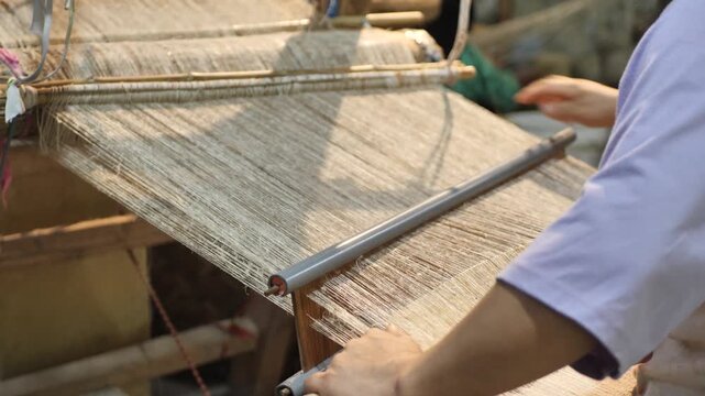 A Vietnamese Hmong woman hand-weaving fabric; people in mountainous regions use flax fibers to weave cloth.