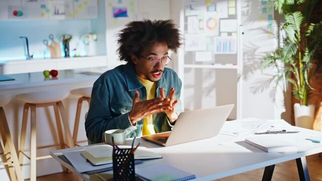 Freelancer talking video call laptop home office. Man discussing project papers.