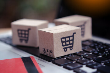 Shopping online. Credit card and cardboard box with a shopping cart logo on laptop keyboard. Shopping service on The online web. offers home delivery © Achira22