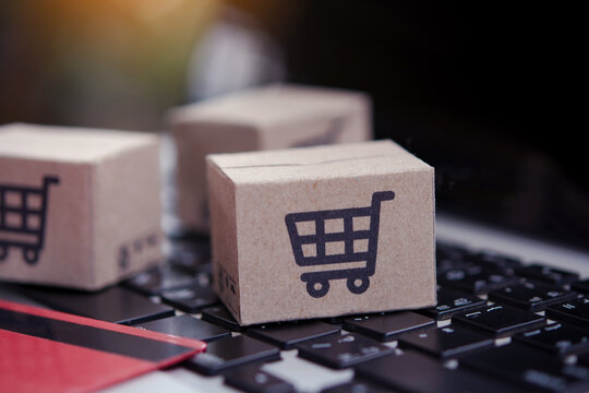 Shopping online. Credit card and cardboard box with a shopping cart logo on laptop keyboard. Shopping service on The online web. offers home delivery