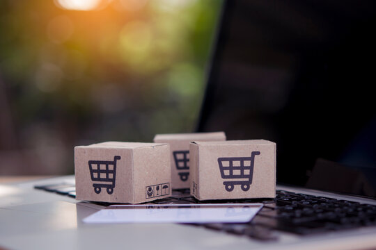 Shopping online. Credit card and cardboard box with a shopping cart logo on laptop keyboard. Shopping service on The online web. offers home delivery