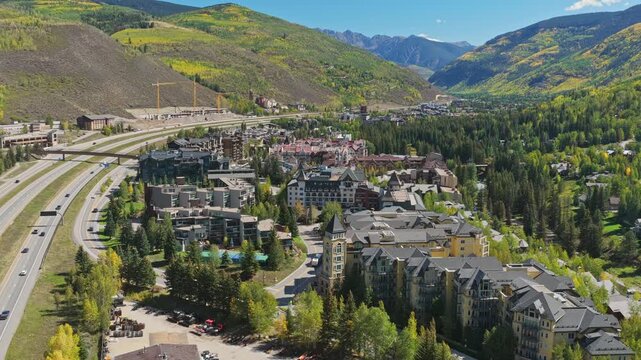 Aerial view showing vail alpine village nestled in rocky mountains during fall drone video 4K