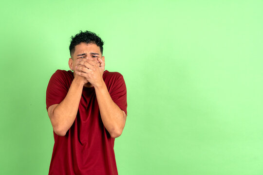 Young man covering mouth feeling shock and fear