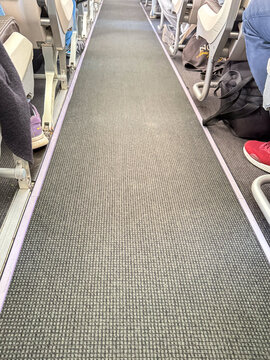 Airplane Cabin Aisle with Passenger Seats and Feet &ndash; Commercial Flight Interior View