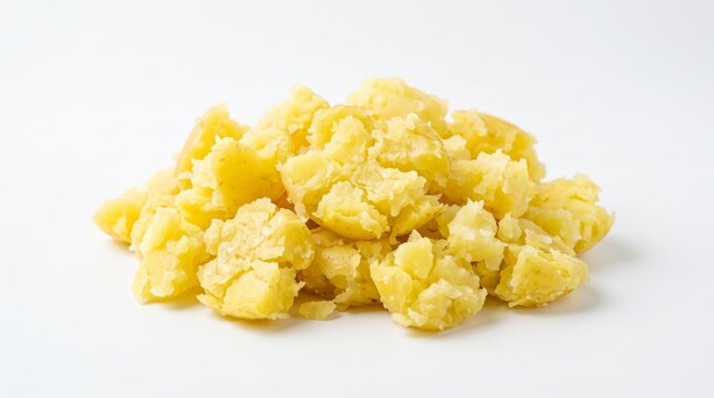 Heap of freshly cooked and roughly smashed yellow potatoes on a simple white background