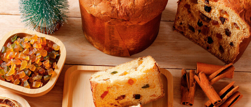 Classic Christmas panettone sliced with candied fruit and spices on a wooden table.