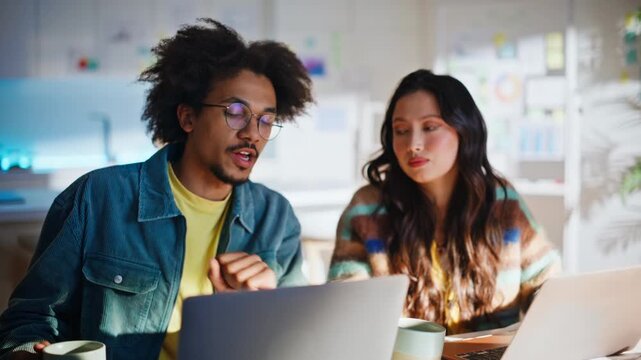 Multiethnic freelancer team discussing project laptop. Coffee break home office.