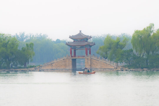 Pavilion on a stone bridge over a misty lake, Summer Palace, Beijing, China