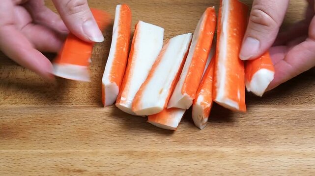 Crab sticks place it on a wooden cutting board. Fish delicacies for cooking a dish. Close-up