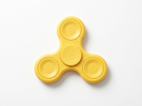Yellow fidget spinner with concave finger pads on white background, top view tri-lobe hand toy for stress relief and focus, minimalist studio shot
