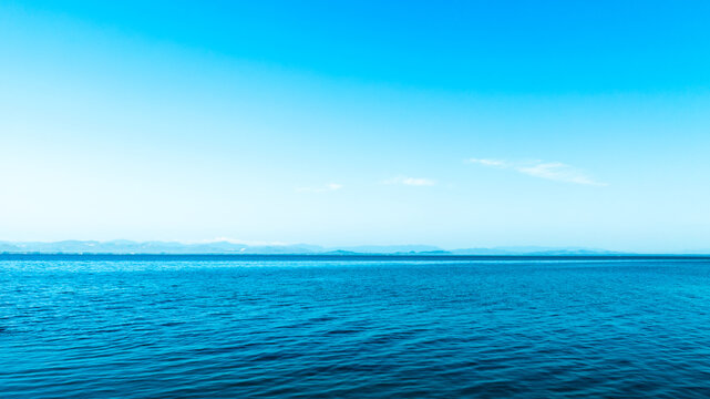 Panorama view clear blue sky meets a glowing white horizon, suggesting a serene, open, and with sunlight of beautiful cloudy sky. landscape or nature sky background	

